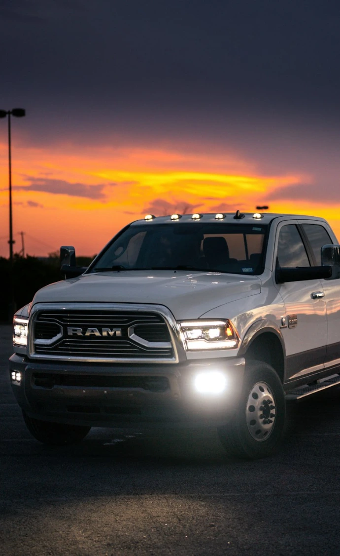 White pickup truck parked at dusk with sunset sky